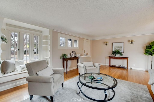 sitting room with a textured ceiling and light wood-type flooring