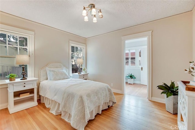 bedroom with a textured ceiling and light wood-type flooring