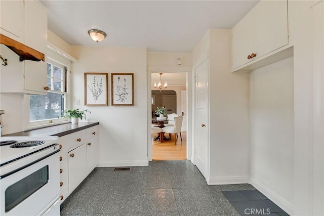 kitchen featuring white cabinetry, a chandelier, and white range with electric stovetop