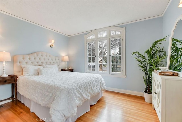 bedroom featuring ornamental molding and light wood-type flooring