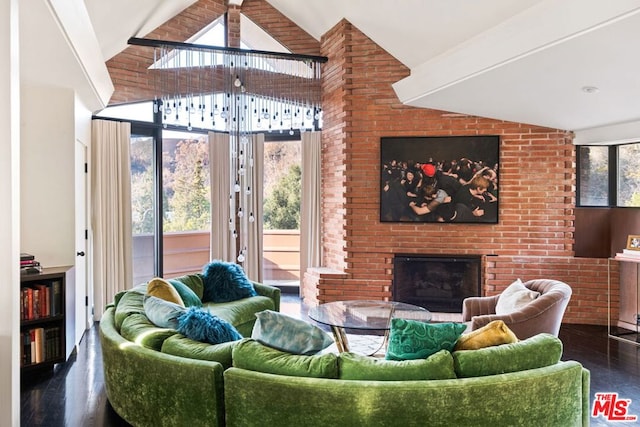 living room featuring lofted ceiling, a brick fireplace, dark wood-type flooring, and brick wall