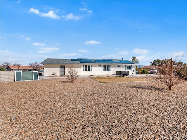 rear view of house featuring solar panels