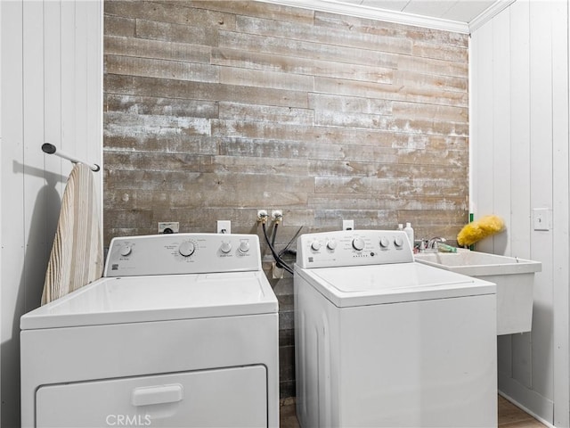 clothes washing area featuring ornamental molding and washer and dryer