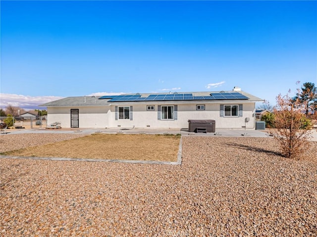 rear view of house featuring cooling unit, a hot tub, and a patio