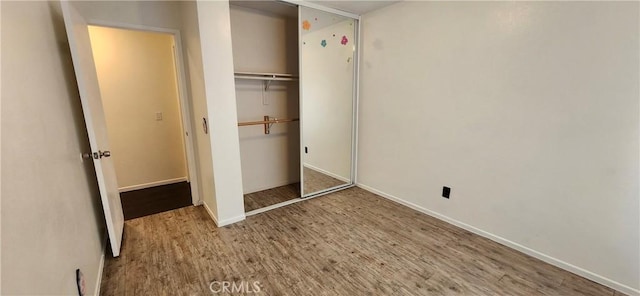 unfurnished bedroom with hardwood / wood-style flooring and a closet