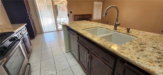 kitchen with sink, light tile patterned floors, dishwasher, range, and light stone countertops