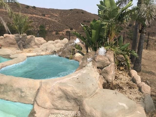 view of swimming pool featuring a mountain view and pool water feature