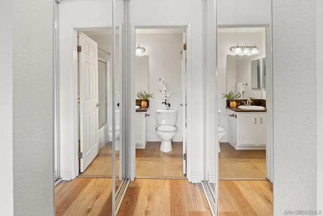 bathroom with vanity, toilet, and hardwood / wood-style floors