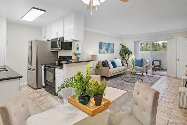 kitchen with light tile patterned floors, ornamental molding, appliances with stainless steel finishes, ceiling fan, and white cabinets