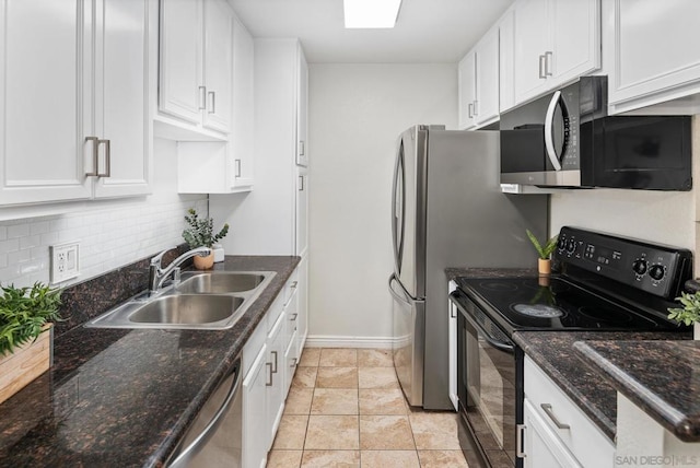 kitchen with sink, dark stone countertops, white cabinets, decorative backsplash, and stainless steel appliances