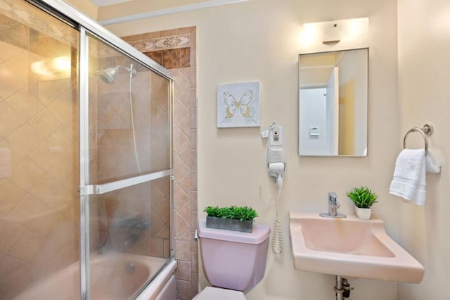 full bathroom with bath / shower combo with glass door, sink, and toilet