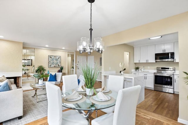 dining room with light hardwood / wood-style flooring and a notable chandelier