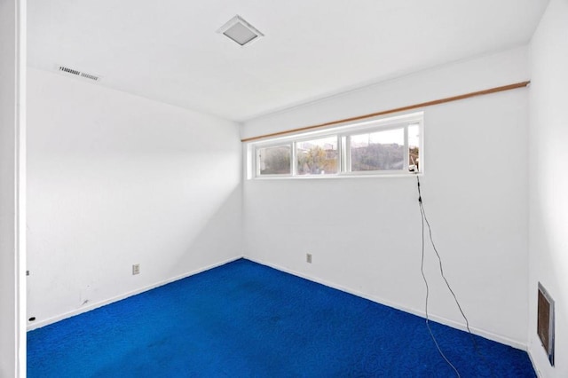 spare room featuring dark carpet