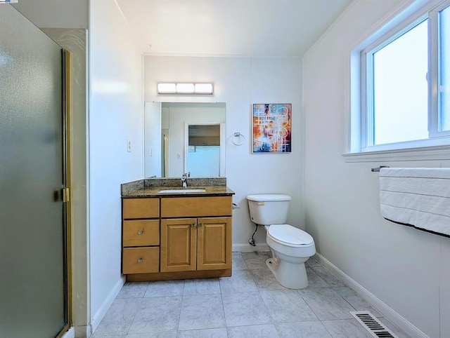 bathroom featuring tile patterned flooring, vanity, an enclosed shower, and toilet