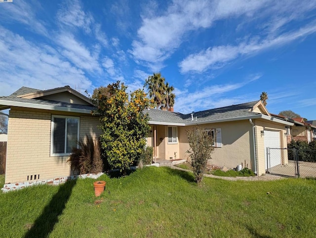 back of property with a garage and a lawn