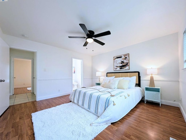 bedroom with ceiling fan, connected bathroom, and dark hardwood / wood-style floors