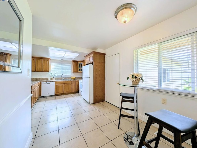 kitchen with light tile patterned flooring, sink, and white appliances