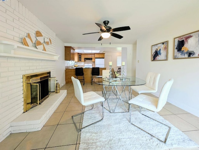 tiled dining space with a fireplace and ceiling fan