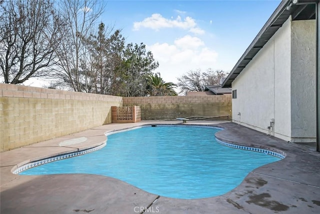 view of swimming pool with a diving board