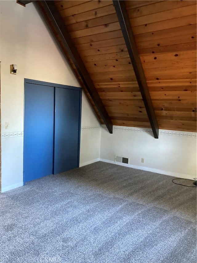 additional living space featuring lofted ceiling with beams, wooden ceiling, and carpet