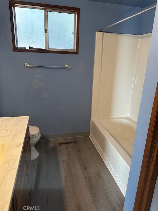 full bathroom featuring hardwood / wood-style flooring, vanity, toilet, and shower / bath combination