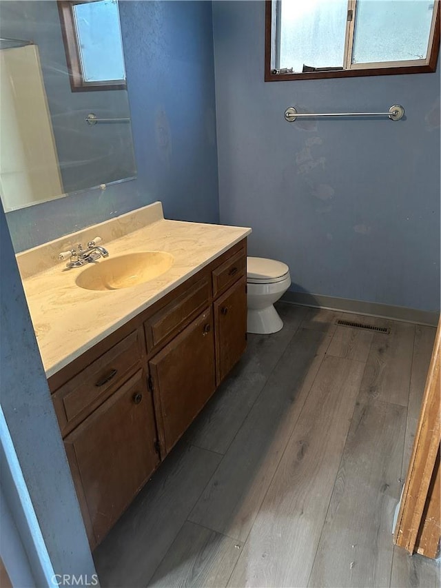 bathroom with hardwood / wood-style flooring, vanity, and toilet