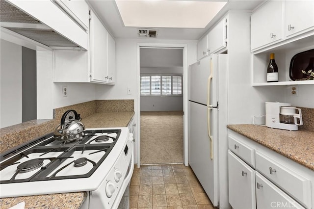 kitchen featuring white cabinetry, white appliances, and light colored carpet