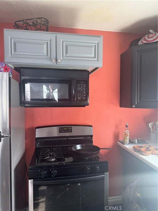 kitchen with white cabinetry, appliances with stainless steel finishes, and a textured ceiling