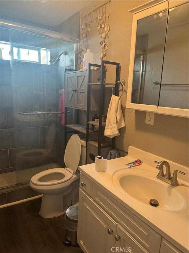 bathroom featuring vanity, toilet, an enclosed shower, and hardwood / wood-style floors