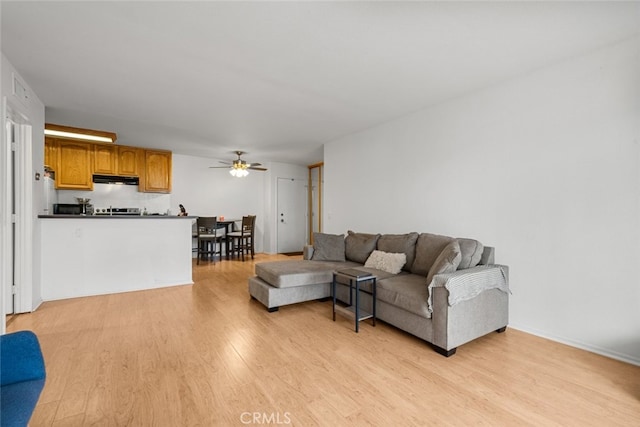 living room with ceiling fan and light hardwood / wood-style flooring