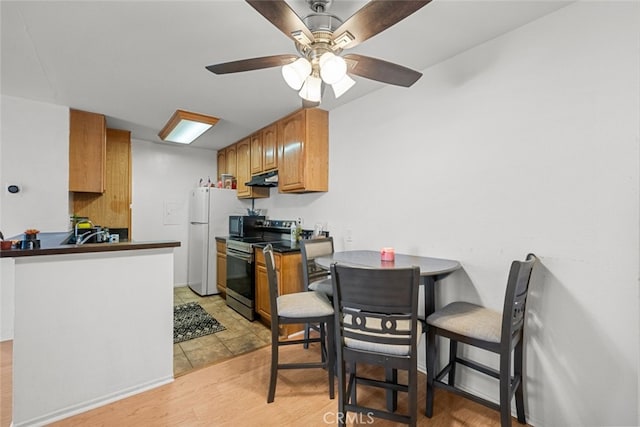 kitchen featuring white refrigerator, electric range, and ceiling fan