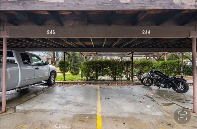 view of parking / parking lot featuring a carport