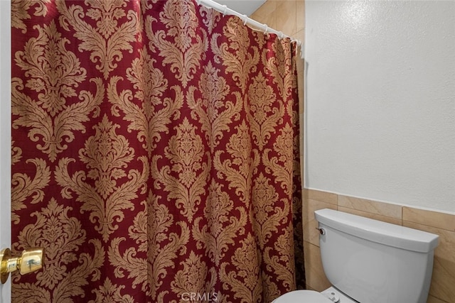 23515 Lyons Ave Unit 210, Valencia, CA 91355 - bathroom featuring wainscoting, tile walls, and a shower with shower curtain