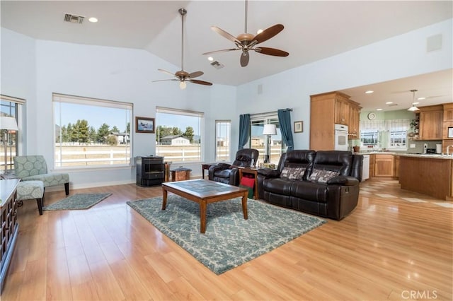 living room with high vaulted ceiling and light hardwood / wood-style floors