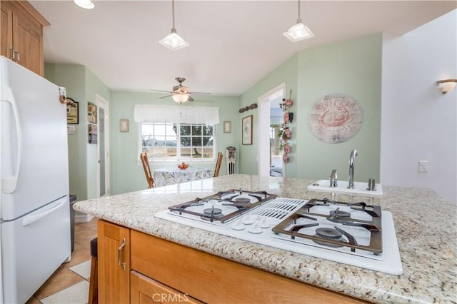 kitchen with pendant lighting, sink, white appliances, ceiling fan, and light tile patterned flooring