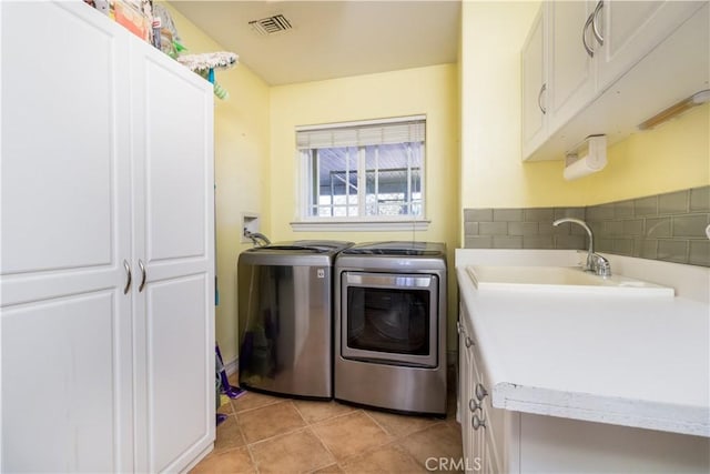 washroom featuring cabinets, light tile patterned flooring, separate washer and dryer, and sink