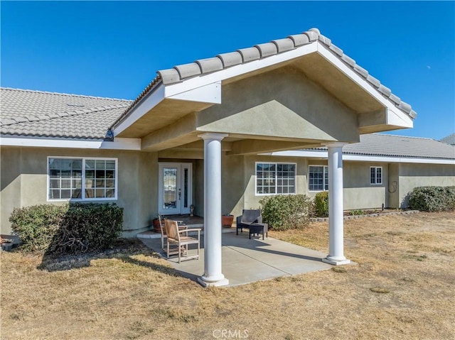 back of property featuring a patio and a lawn