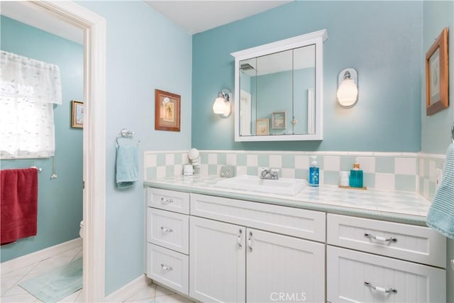 bathroom with tasteful backsplash, vanity, tile patterned floors, and toilet