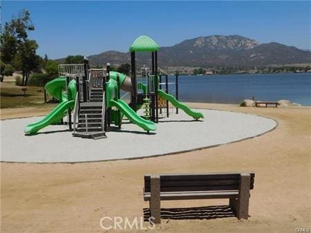 view of jungle gym featuring a water and mountain view