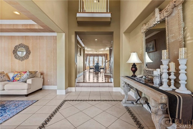 entrance foyer with crown molding and tile patterned flooring