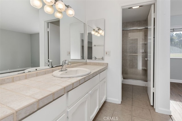 bathroom featuring tile patterned flooring, vanity, and a shower with shower door