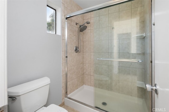 bathroom with toilet and an enclosed shower