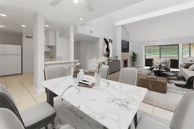 dining room with sink, light tile patterned floors, vaulted ceiling, and ceiling fan