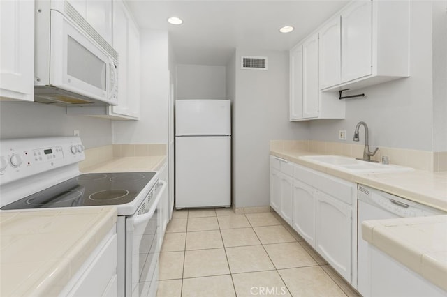 kitchen featuring white cabinetry, sink, white appliances, and tile counters