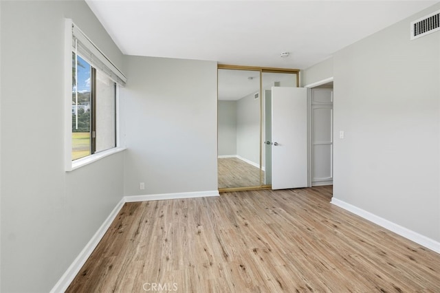 empty room with light hardwood / wood-style flooring