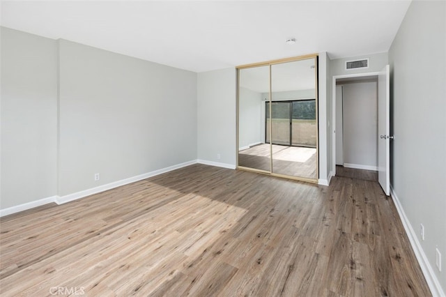 unfurnished bedroom with light hardwood / wood-style floors and a closet