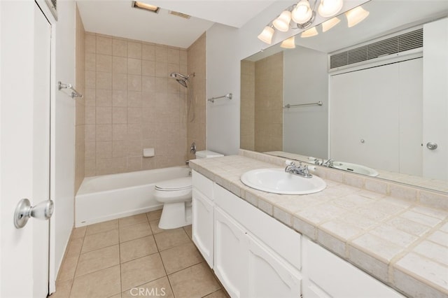 full bathroom with tiled shower / bath, vanity, tile patterned floors, and toilet