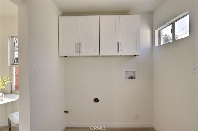 washroom with baseboards, hookup for a washing machine, and cabinet space