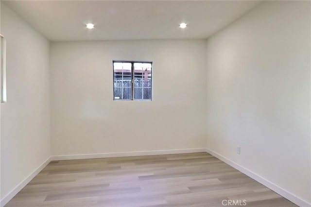 empty room featuring baseboards, light wood finished floors, and recessed lighting