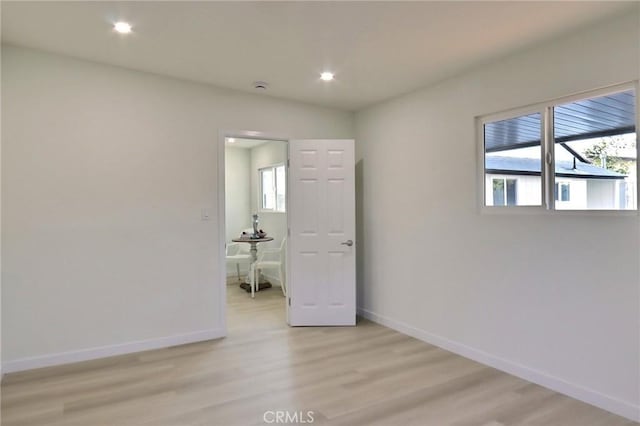 spare room with light wood-style flooring, recessed lighting, and baseboards